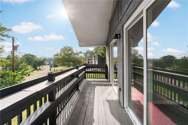 a view of balcony with wooden floor and fence