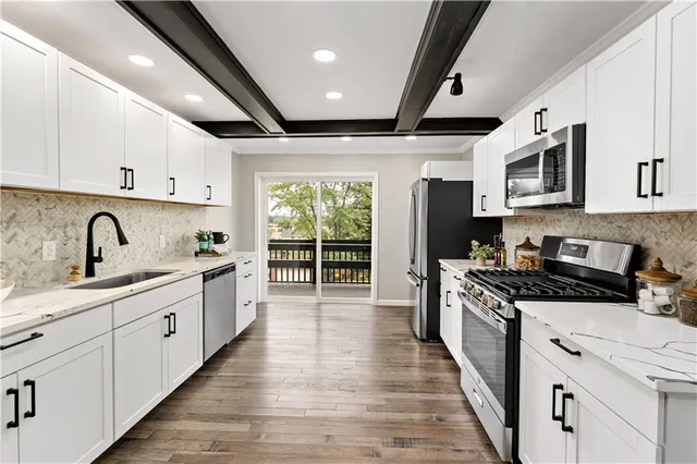 a kitchen with stainless steel appliances granite countertop a sink stove and refrigerator