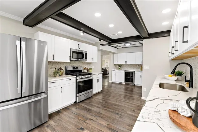a kitchen with granite countertop stainless steel appliances and wooden floor