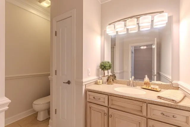 a bathroom with a granite countertop sink a toilet and a mirror