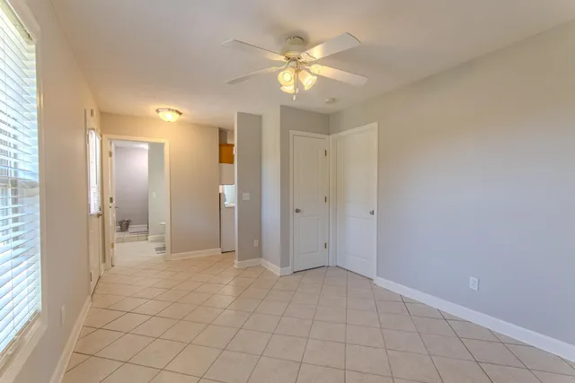 a view of an empty room and chandelier fan