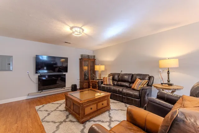 a living room with furniture a flat screen tv and a lamp