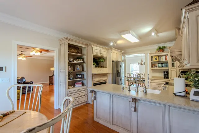 a kitchen with stainless steel appliances wooden floor dining table and chairs