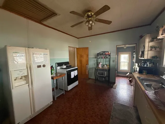 a room with lots of books and white cabinets