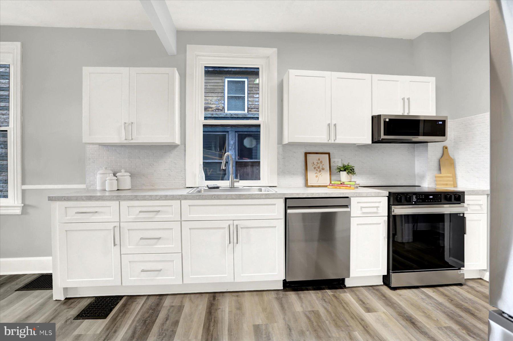 497 State Street Enola, PA 17025 - Photo 6 of 47 a kitchen with stainless steel appliances granite countertop a stove and white cabinets