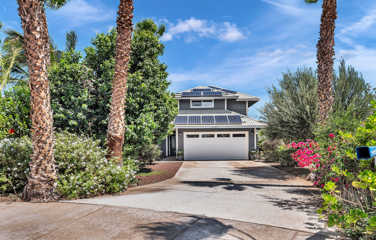 a front view of a house with a yard and fountain in middle