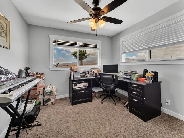 a view of a workspace with furniture and a window