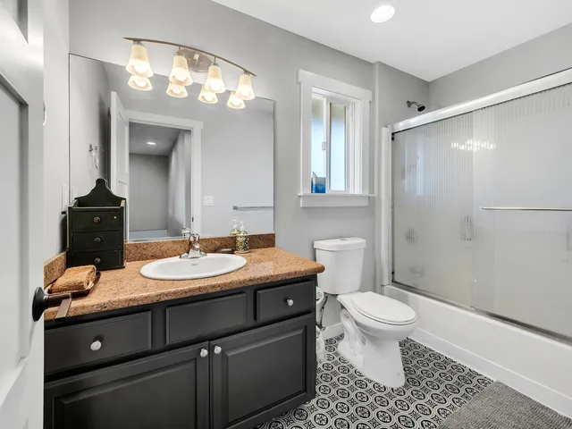 a bathroom with a sink a toilet and a mirror