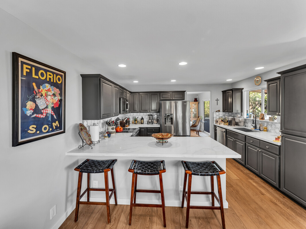 68-3679 Kokee Street Waikoloa, HI 96738 - Photo 7 of 28 a kitchen with stainless steel appliances kitchen island granite countertop a dining table chairs and a refrigerator