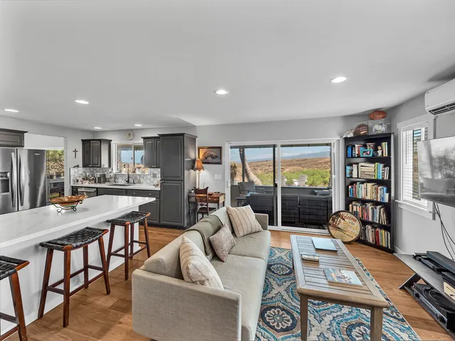 a living room with furniture a rug and a large window