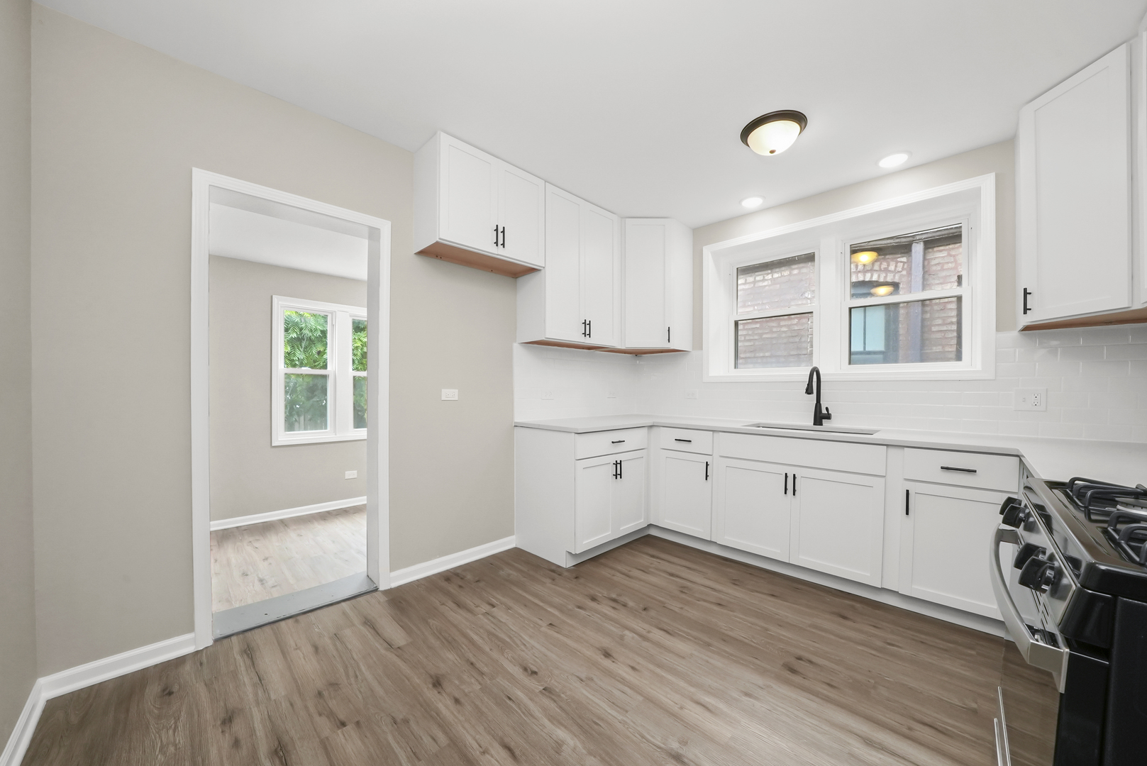 3229 Maple Avenue Brookfield, IL 60513 - Photo 5 of 14 a kitchen with wooden floors and white cabinets