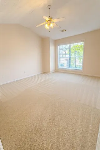 an empty room with a window and a ceiling fan