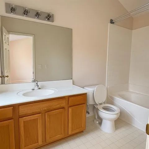 a bathroom with a granite countertop sink a toilet and a mirror