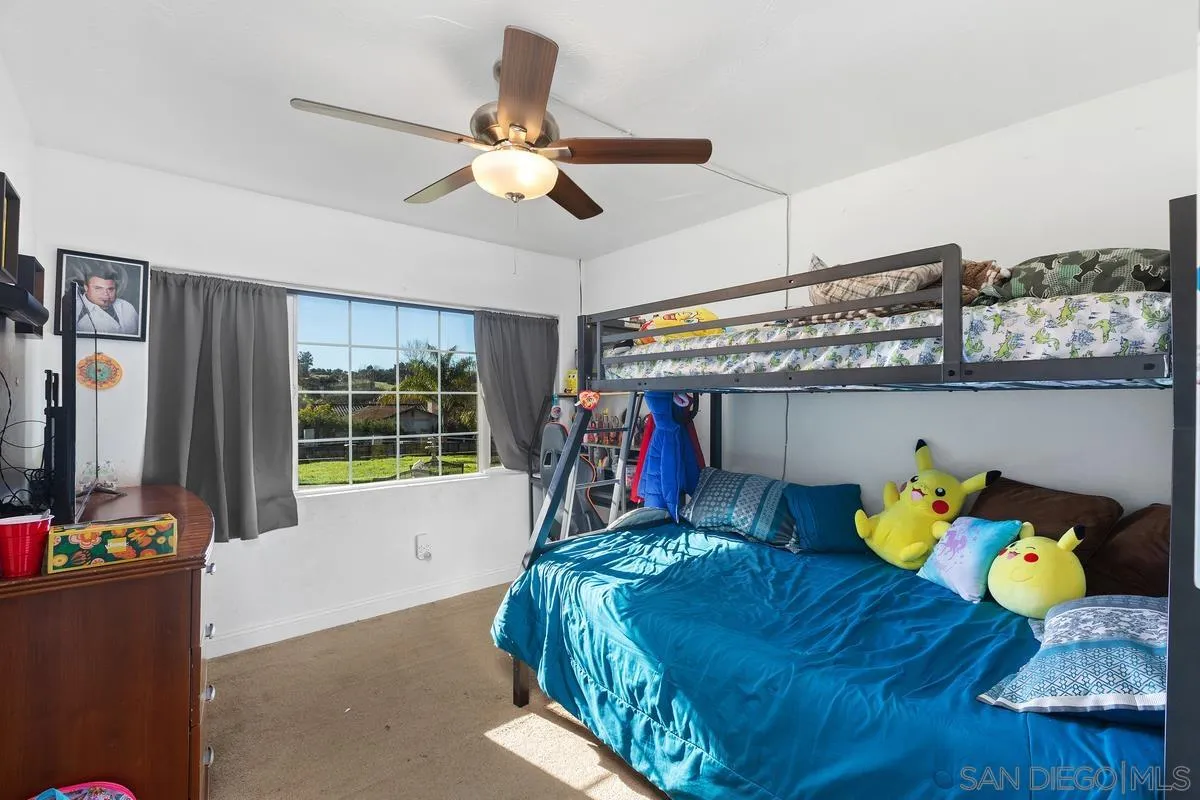 14164 Lyons Valley Road Jamul, CA 91935 - Photo 23 of 33 a bedroom with a bed and ceiling fan