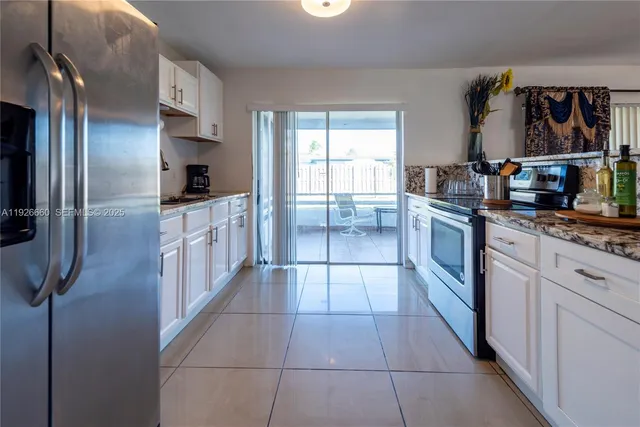 a kitchen with stainless steel appliances granite countertop a refrigerator and a stove top oven