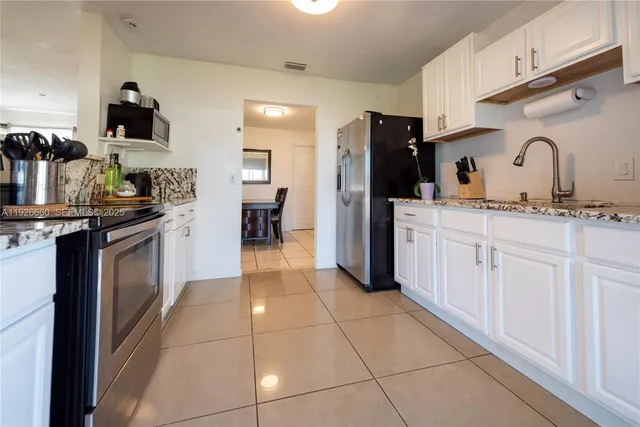 a kitchen with stainless steel appliances a sink stove and cabinets