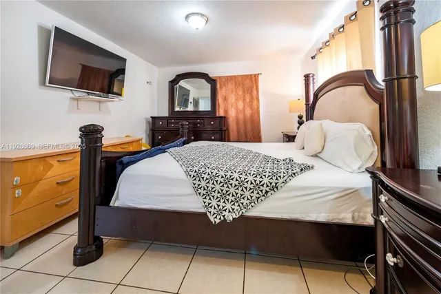 a bedroom with a bed and a flat screen tv