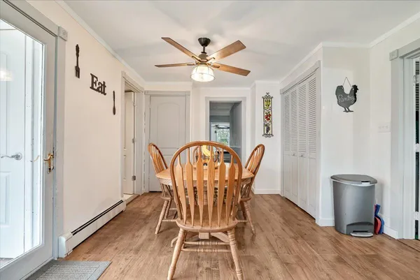 a dining room with furniture a chandelier and wooden floor