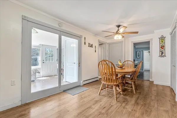 a dining room with furniture a chandelier and wooden floor