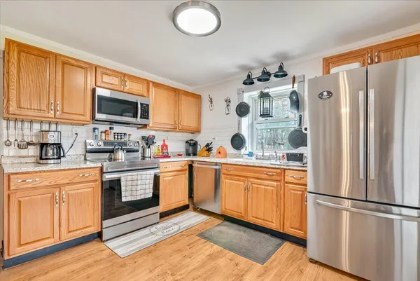 a kitchen with stainless steel appliances granite countertop a refrigerator and a stove top oven