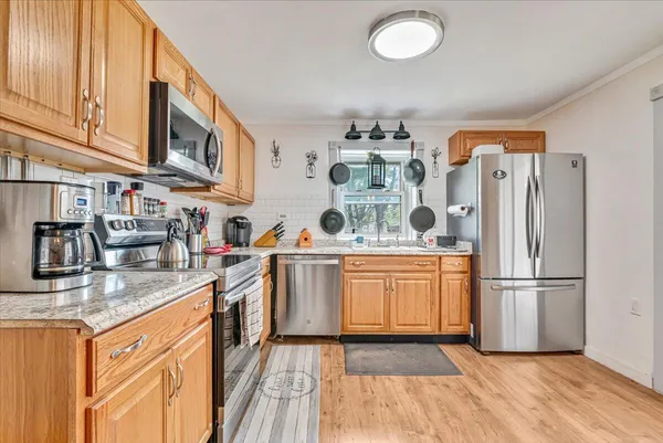 a kitchen with appliances a sink and cabinets