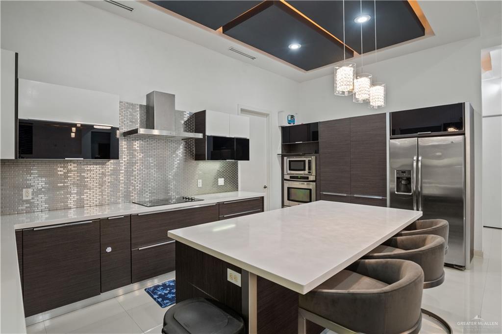 206 North Mockingbird Avenue Mission, TX 78572 - Photo 7 of 22 a kitchen with stainless steel appliances a table chairs and a refrigerator