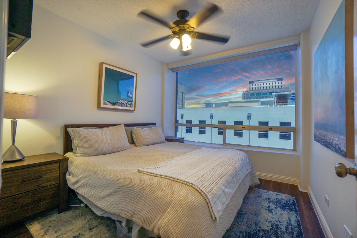1212 Guadalupe Street, Unit 402 Austin, TX 78701 - Photo 10 of 20 a bedroom with a bed and a chandelier