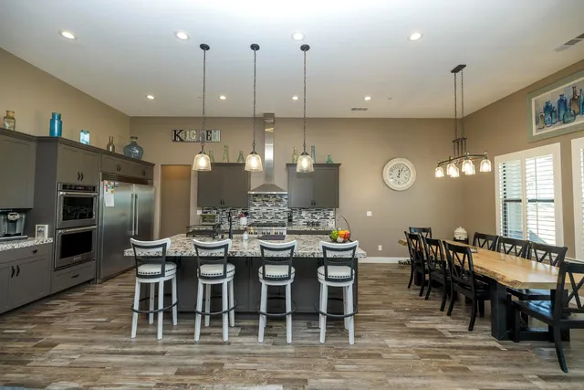a view of a dining room and livingroom with furniture wooden floor a chandelier