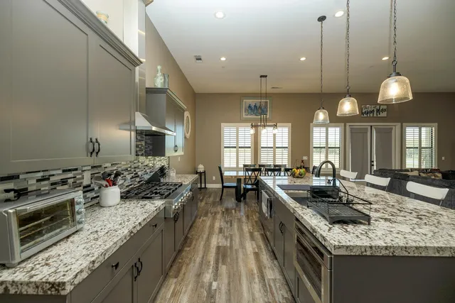 a kitchen with stainless steel appliances granite countertop a refrigerator and a sink