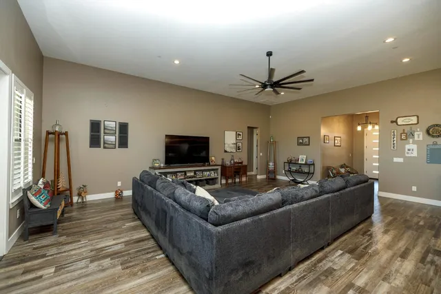 a living room with furniture kitchen view and a wooden floor