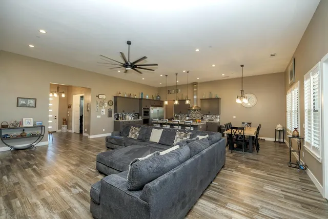 a large kitchen with a large counter top space a sink stainless steel appliances and cabinets