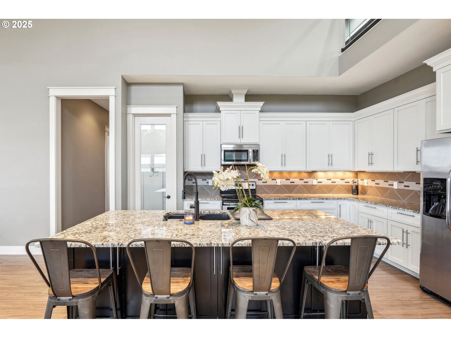 18147 Southeast Troge Road Damascus, OR 97089 - Photo 13 of 45 a kitchen with granite countertop a dining table chairs and white cabinets