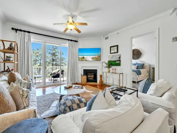 a living room with furniture a fireplace and a large window