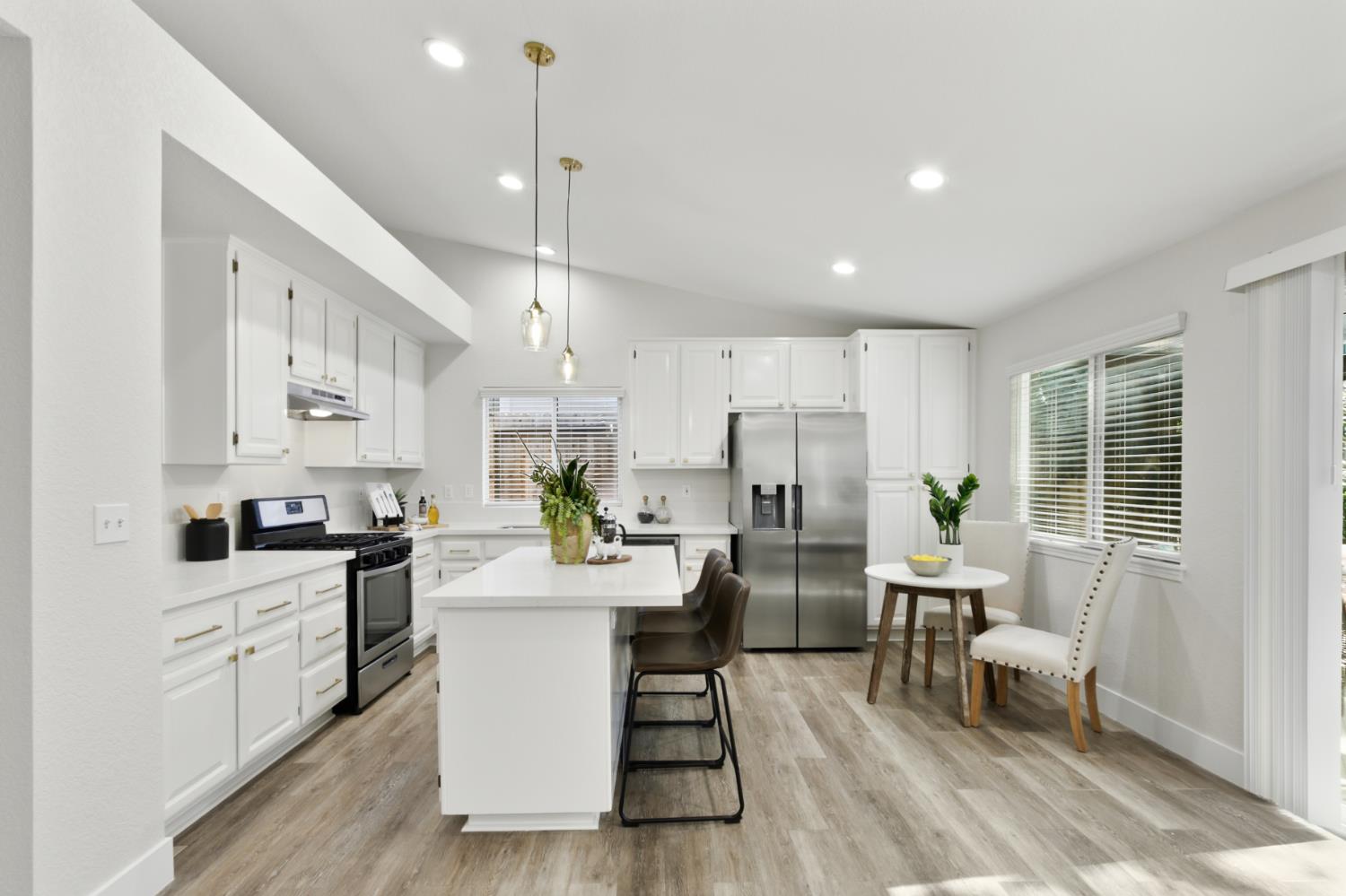 4711 Stuart Street Rocklin, CA 95765 - Photo 12 of 48 a kitchen with stainless steel appliances kitchen island granite countertop a stove a sink a refrigerator and white cabinets with wooden floor