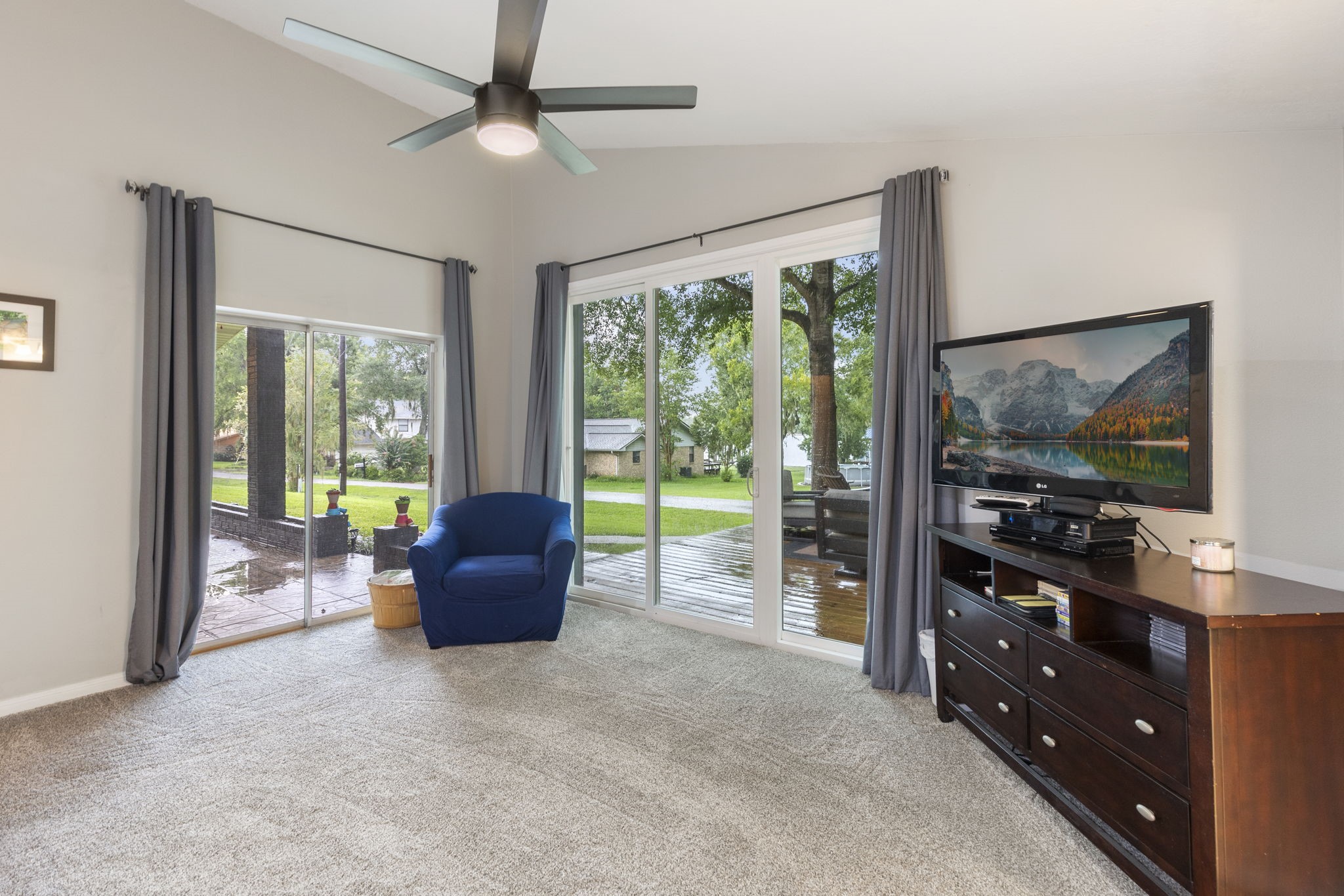 245 Lakeland Road Huntsville, TX 77320 - Photo 21 of 49 The primary bedroom features two sets of large sliding glass doors that open to the covered back porch and opened deck.