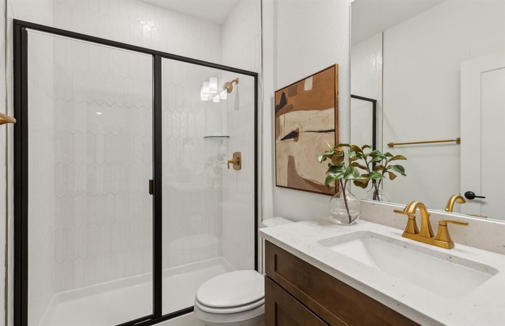 300 Brookhurst Road Little Elm, TX 75068 - Photo 17 of 20 a bathroom with a granite countertop sink toilet and shower