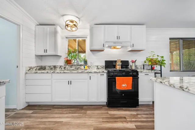 a kitchen with stainless steel appliances granite countertop a stove a cabinets and a window