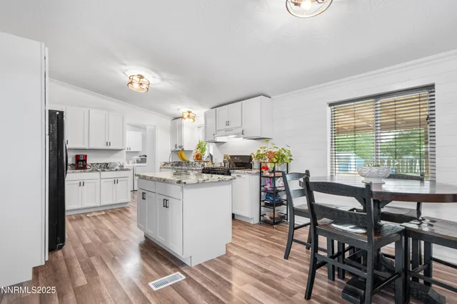 a kitchen with granite countertop appliances cabinets and a dining table