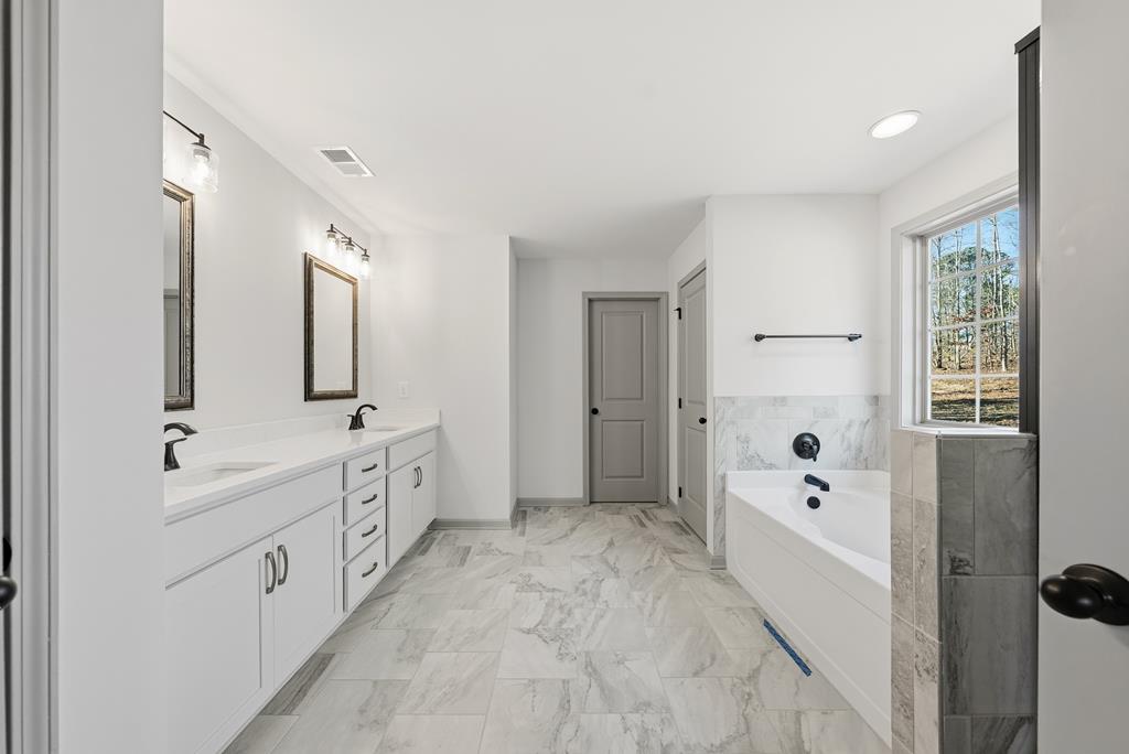 331 Lee Road 0357 Valley, AL 36854 - Photo 18 of 30 a spacious bathroom with double vanity a mirror a bathtub and shower