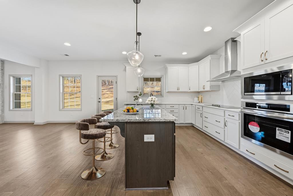 331 Lee Road 0357 Valley, AL 36854 - Photo 7 of 30 a kitchen with stainless steel appliances granite countertop a sink a stove and a wooden floors