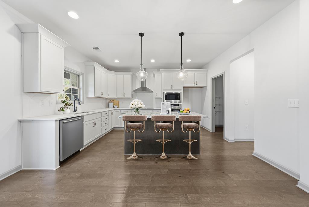 331 Lee Road 0357 Valley, AL 36854 - Photo 8 of 30 a kitchen with kitchen island a dining table chairs and white cabinets