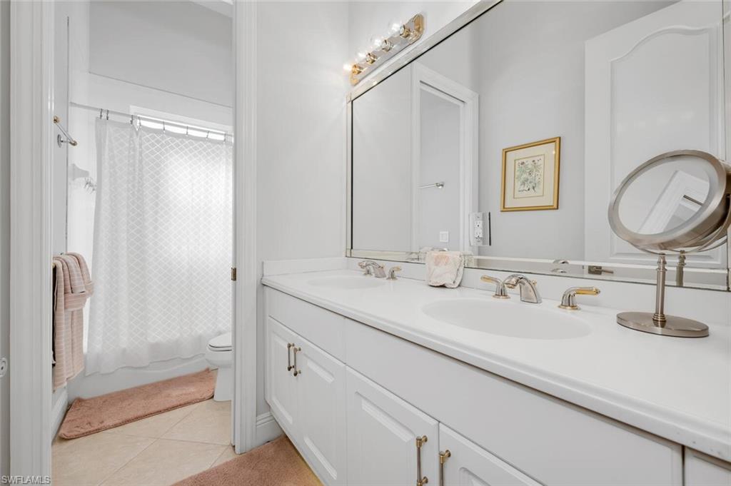 400 Terracina Way Naples, FL 34119 - Photo 15 of 29 Full bathroom with tile patterned floors, shower / bath combination with curtain, toilet, and vanity