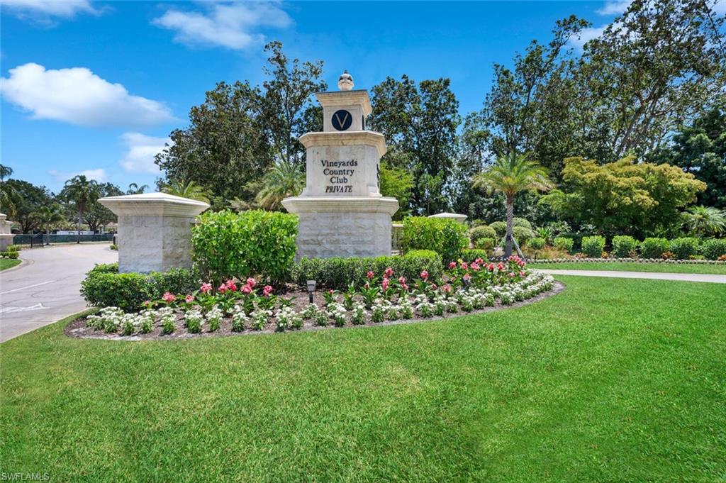 400 Terracina Way Naples, FL 34119 - Photo 27 of 29 Community sign featuring a lawn