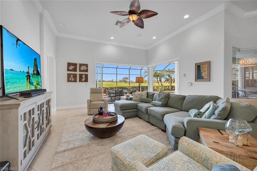 400 Terracina Way Naples, FL 34119 - Photo 6 of 29 Tiled living room with crown molding, a towering ceiling, and ceiling fan