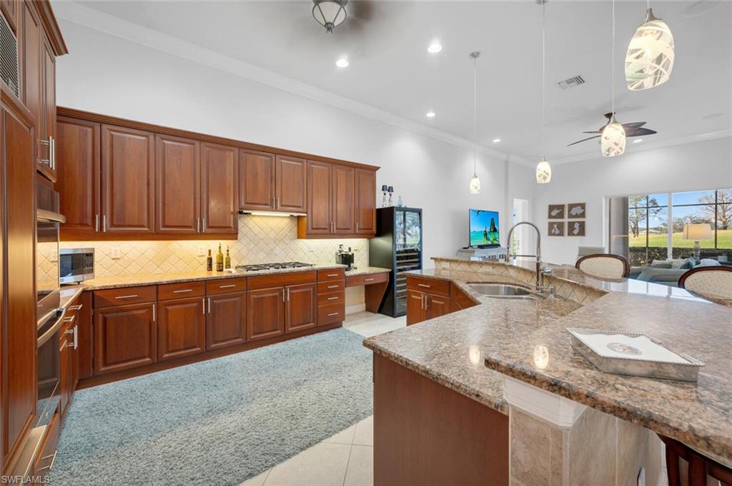 400 Terracina Way Naples, FL 34119 - Photo 8 of 29 Kitchen featuring light stone countertops, sink, hanging light fixtures, light tile patterned floors, and appliances with stainless steel finishes