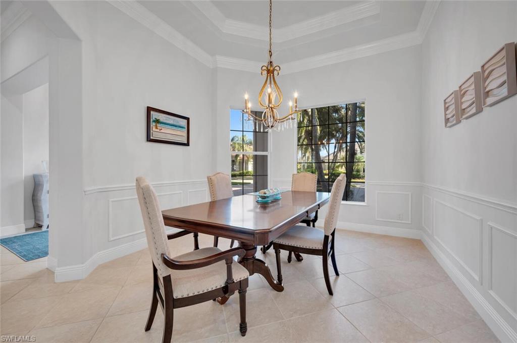 400 Terracina Way Naples, FL 34119 - Photo 9 of 29 Tiled dining room featuring a raised ceiling, ornamental molding, and a chandelier