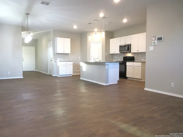a large kitchen with a large counter top appliances and cabinets