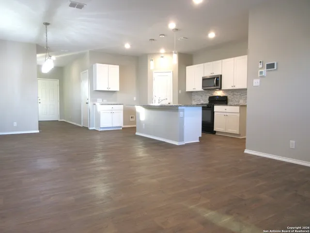 a large kitchen with a large counter top appliances and cabinets