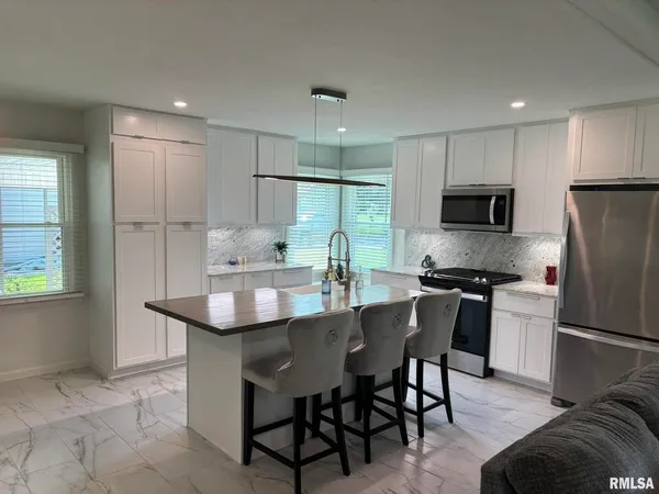 a kitchen with kitchen island a sink stove and refrigerator