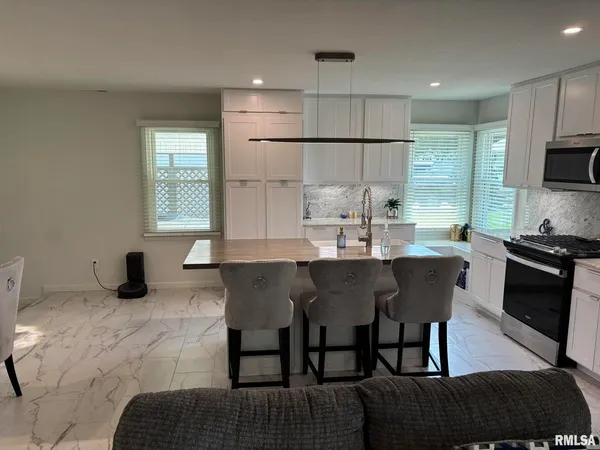 a kitchen with a dining table chairs and refrigerator